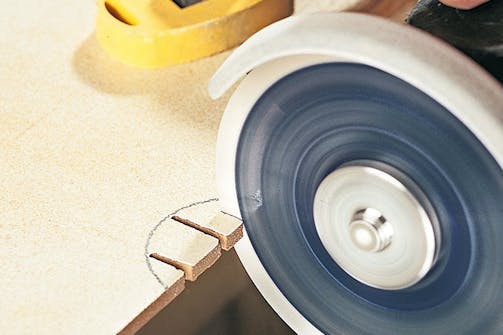 Hak og buer i fliser/klinker med vinkelsliber: En bue i en flise klares ved at skære riller i den del, der skal fjernes. Hak og buer i fliser/klinker med vinkelsliber: En bue i en flise klares ved at skære riller i den del, der skal fjernes.